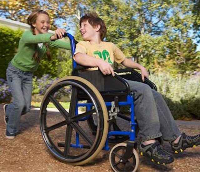 сестра катает брата в инвалидном кресле